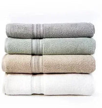 Linen bath towels folded in beige, gray, green, and white
