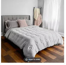 King size comforter on bed, medium gray quilted top with corner stitching