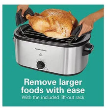 Electric roaster oven with wire rack holding roasted chicken and black lift handles