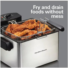 Deep fryer with open lid and wire basket holding fried food