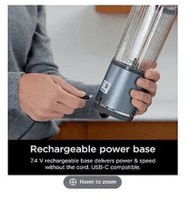 Rechargeable power base blender with denim-blue cup held in hand.