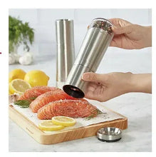 Stainless steel KitchenAid seasoning grinder held in hand, with grinding top
