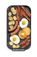 Black reversible grill and griddle with cooked breakfast items: eggs, bacon, sausages
