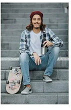 Pair of black beer coolers with silver accents resting on a skateboard