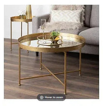 Round coffee table with dark glass top and gold metal frame