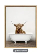 Framed canvas wall art of a Highland cow in a white tub