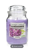 Purple scented jar candle with glass lid and Yankee Candle label, Sweet Lilac.