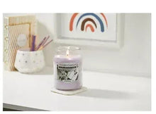 Small scented candle jar with frosted glass lid and scenic label