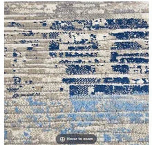 Area rug with cream base and blue abstract blocks, flatwoven texture