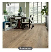 Vinyl plank flooring with light wood-look planks in a wide-room view