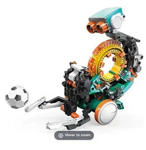 Programmable mechanical robot with teal and orange wheel body, holding a soccer ball