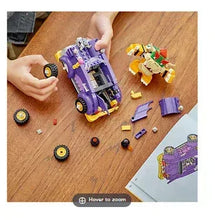 LEGO Icons Wildflower Bouquet building set parts and purple vehicle on wooden floor