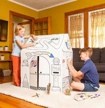 Cardboard garage playhouse with open door graphic while two children play