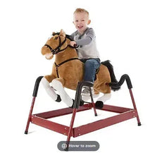 Brown plush rocking horse with spring base and saddle, child seated on it.