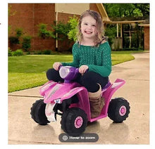 Pink toy quad ride-on with purple details, ridden by a child outdoors