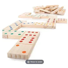 Giant wooden domino tiles with colorful dots scattered around a base