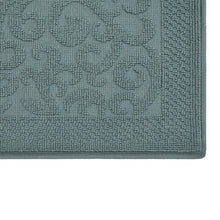 Close-up of dark gray-blue bath mat texture with raised swirl design