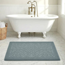 Gray-blue textured bath mat with raised swirl pattern and border