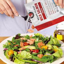 Ready-to-eat salmon pouch with salmon flakes spilling over a salad bowl