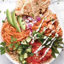 Salad bowl topped with smoked salmon, mixed greens, tomatoes, cucumbers, and onions