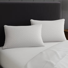 White quilted rectangular pillows on a bed, diamond texture