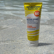 SPF 50 sunscreen lotion tube, yellow top with white squeeze base.