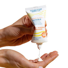 Invisible mineral sunscreen dispensing from tube into cupped hands