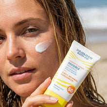 Invisible mineral sunscreen SPF 50 tube, with applied cream on cheek