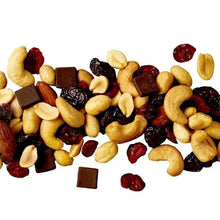 Trail mix handful with roasted cashews, peanuts, dried cranberries, and dark chocolate cubes