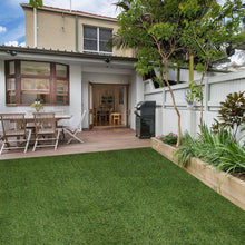 Evergreen artificial grass lawn in a backyard patio area, green turf surface
