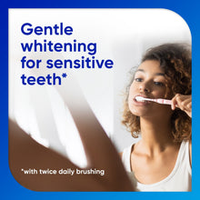 Sensodyne Extra Whitening toothpaste panel with woman brushing teeth