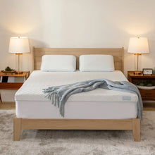 Cooling memory foam mattress topper with quilted white cover and gray throw blanket