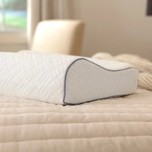 Contour memory foam pillow with white cover and blue piping, standing upright
