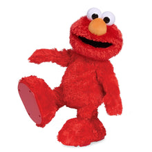 Red Elmo plush doll with black mouth and big white eyes