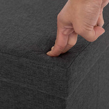 Dark gray foldable storage cube ottoman with hand pressing the top