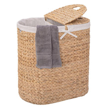 Round water hyacinth laundry hamper with white liner, bow tie, and folded gray towel