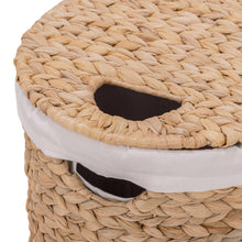 Water hyacinth laundry hamper with woven rim, white liner, and dark interior opening