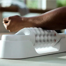 Rolling massager with ribbed roller head on a stretched leg, light gray base