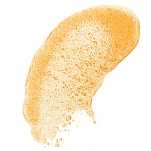 Orange shea sugar scrub paste with fine sugar granules on a scoop