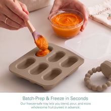 Tan silicone fruit feeder tray filled with orange puree and spoon for batching