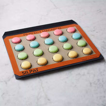 Silpat perforated baking tray with macarons on dotted surface