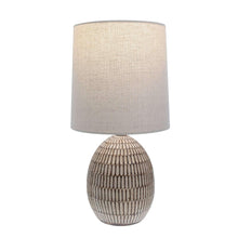 Ceramic table lamp with beige fabric shade and carved textured base