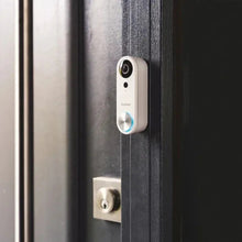 Wired video doorbell camera mounted beside door knob; blue ring and lens visible