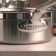 Stainless steel saucepan handle with embossed Hestan logo and rivets, polished finish