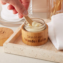 Wooden spoon scooping Wonder Balm from an open jar