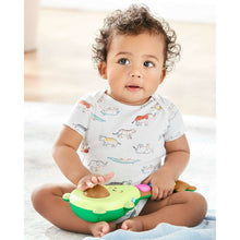 Green rock-a-mole guitar baby toy with colorful top lights on infant’s lap