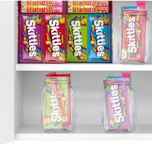 Open candy box with Skittles and Starburst bags and two clear Skittles jars