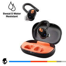True wireless earbuds with open charging case, black earbuds with orange logo, showing in-ear tips.