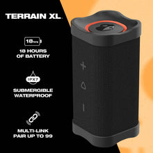 Black rugged wireless speaker with orange top accent and textured fabric grille