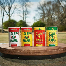 Four Cajun seasoning cans standing on a circular wood display outdoors